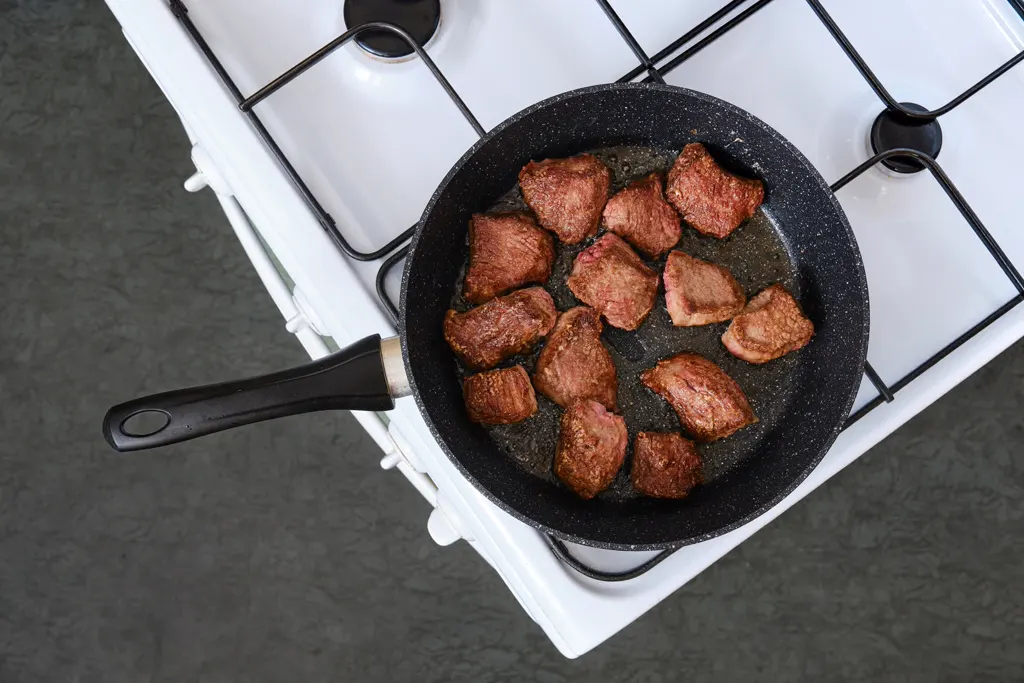 Browning beef cubes in a pan for beef bourguignon