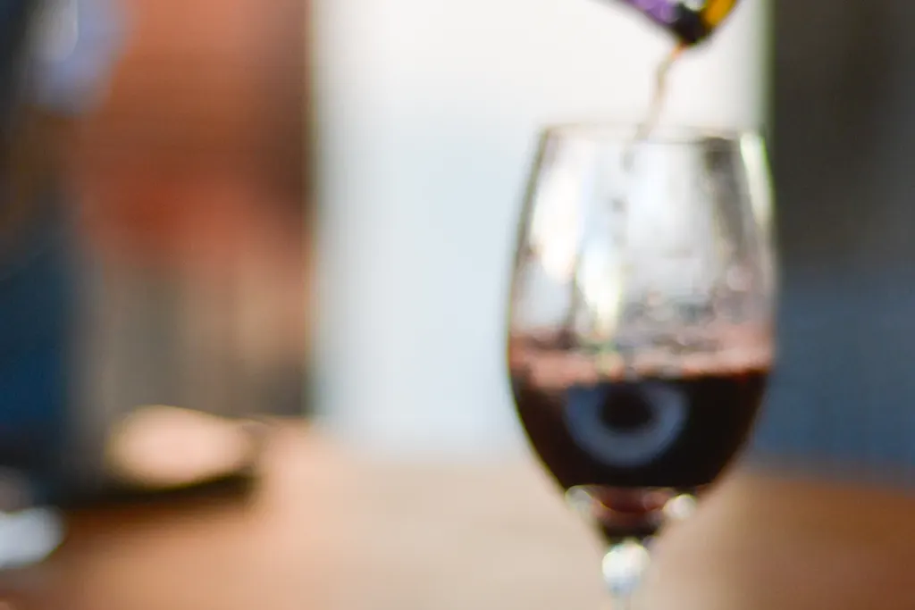 Pouring red wine over beef bourguignon