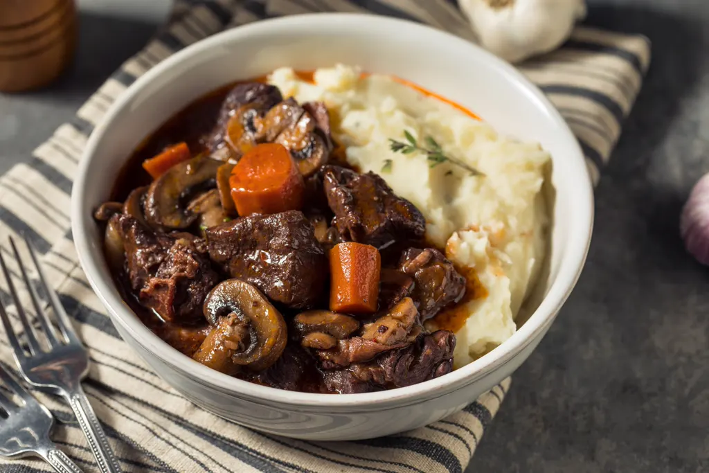 Beef bourguignon served over mashed potatoes