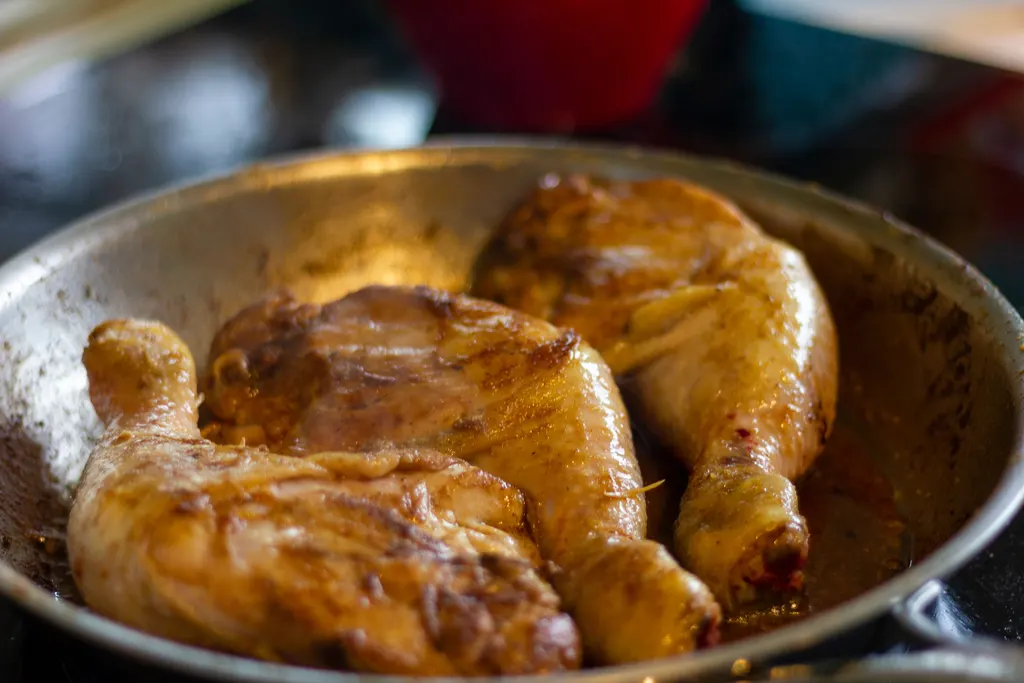 Chicken cooking in a pan, close-up