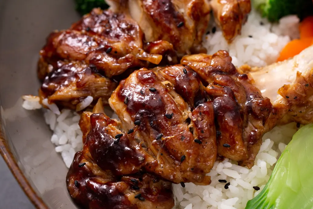 Glazed bourbon chicken with rice and vegetables, served hot