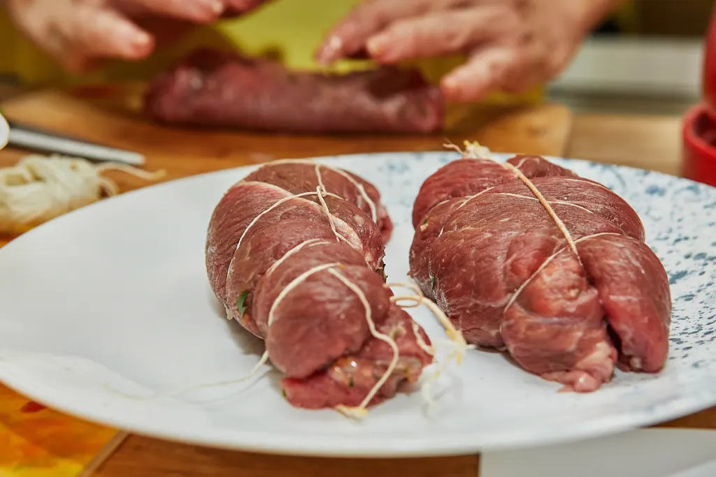 Tying braciole rolls securely with kitchen string