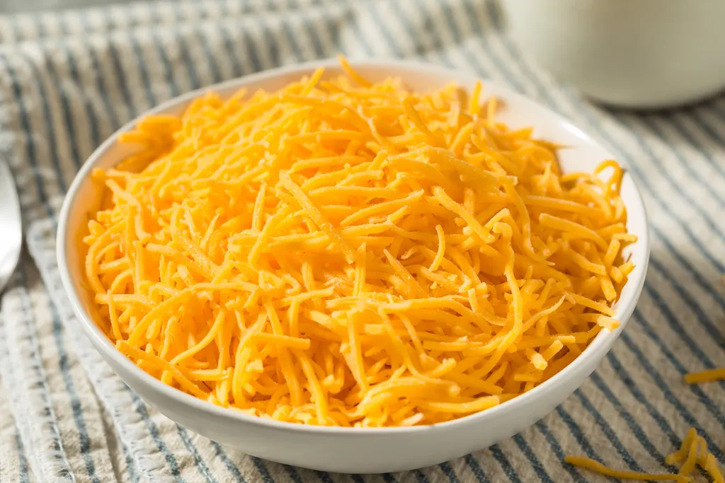 Bowl of shredded cheddar cheese