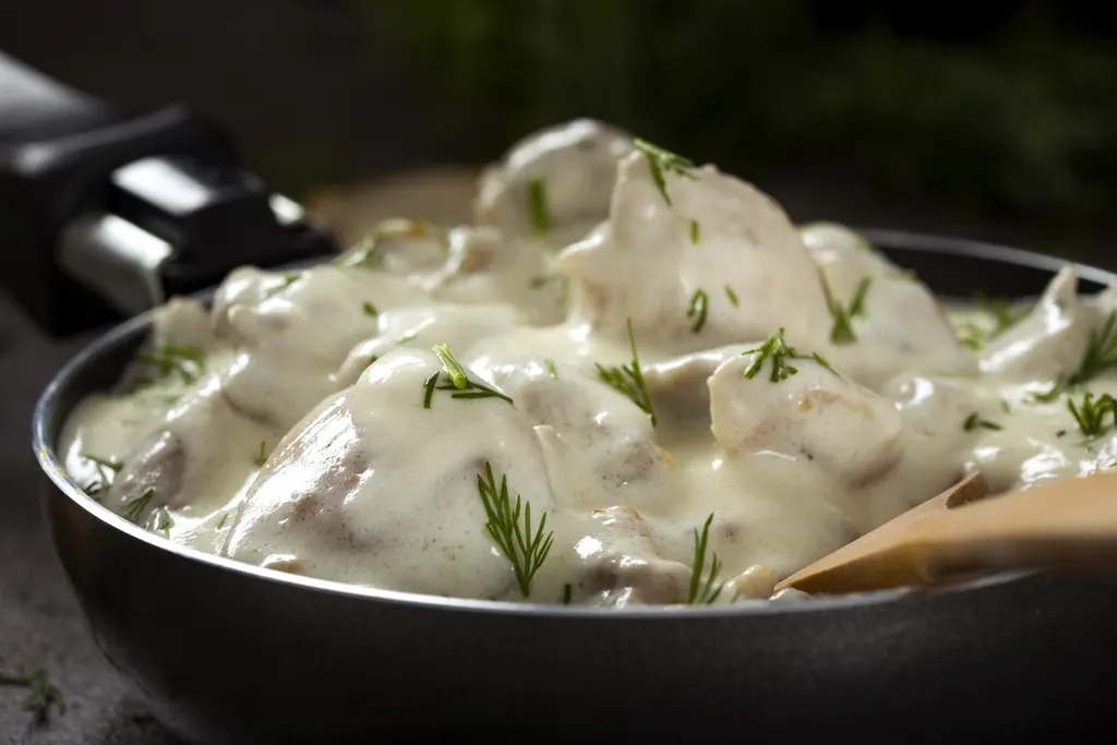 Creamy chicken dish garnished with fresh herbs