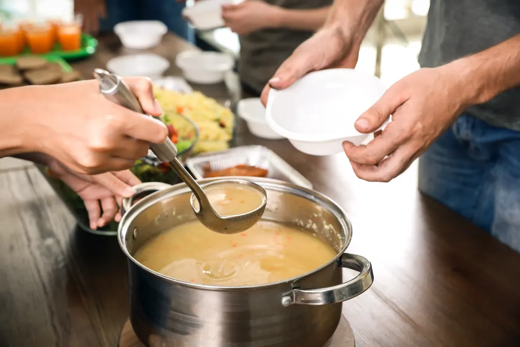 Serving hearty homemade food from a big pot to a group