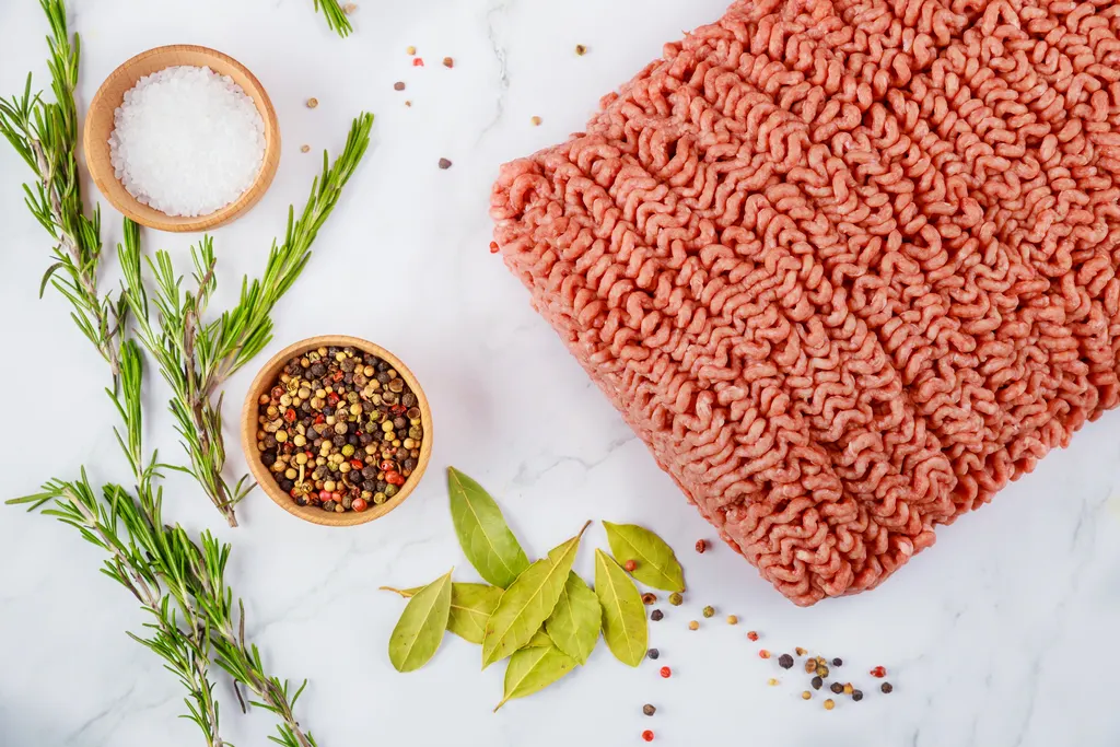 Fresh ground beef with rosemary and pepper, close-up