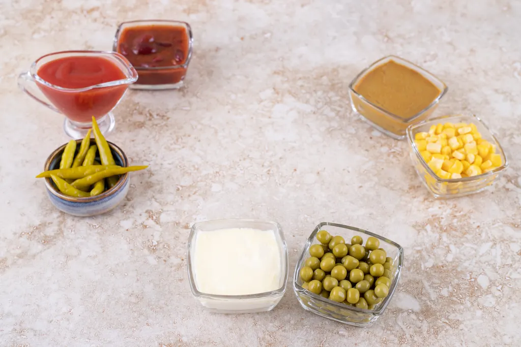 Small bowls of colorful burger toppings and condiments on a table