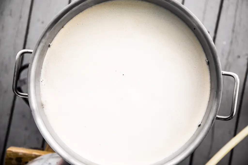 Glossy coconut milk mixture in a metal pot