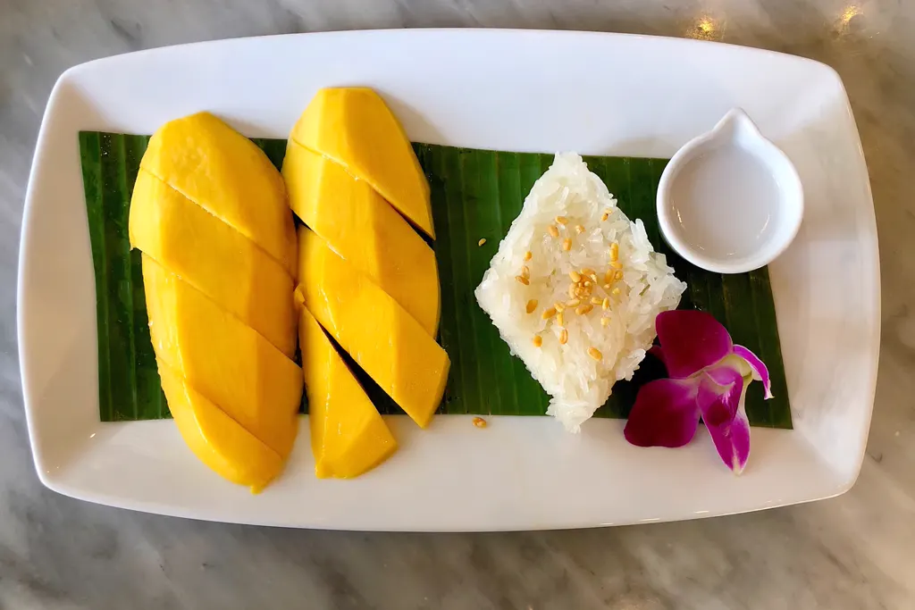 Mango sticky rice plated with coconut sauce
